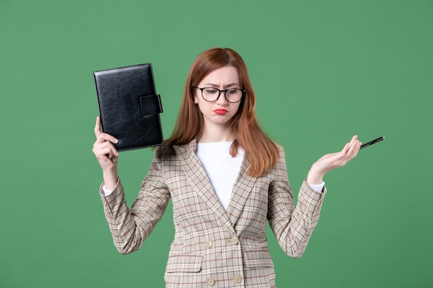 Foto grátis retrato de professora segurando o bloco de notas verde