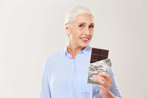 Foto grátis retrato de senhora encantadora, segurando a barra de chocolate