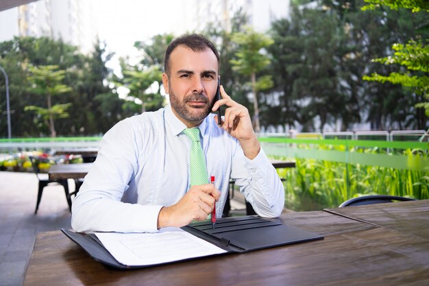 Retrato, de, sério, homem negócios, conversa, sócio, telefone