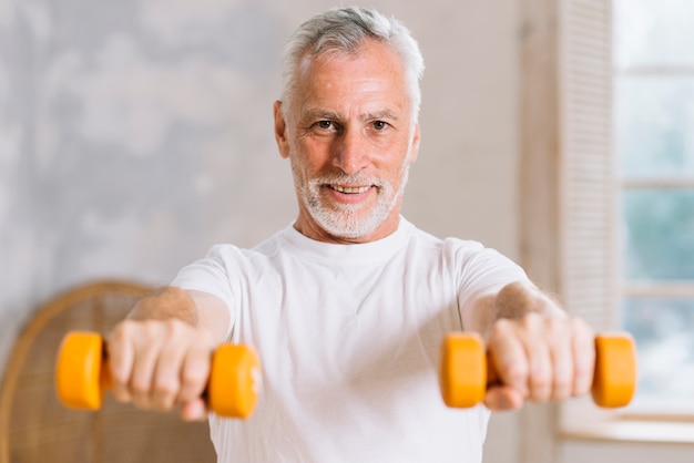 Retrato, de, sorrindo, homem idoso, segurando, dumbbells