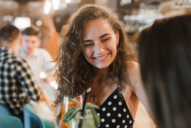 Retrato, de, sorrindo, mulher jovem, desfrutando, bebidas