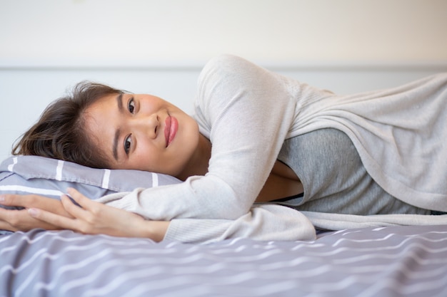 Retrato, de, sorrindo, mulher jovem, mentindo cama