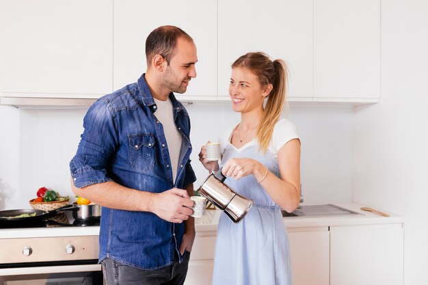 Retrato, de, sorrindo, par jovem, bebendo, a, café, ficar, em, a, cozinha