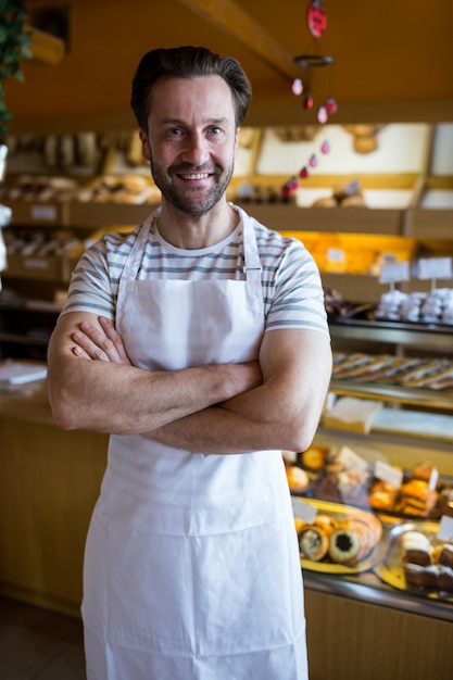 Retrato de sorrindo proprietário pé na padaria