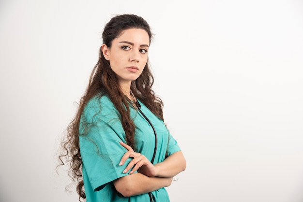 Retrato de trabalhador de saúde feminino posando com as mãos cruzadas.