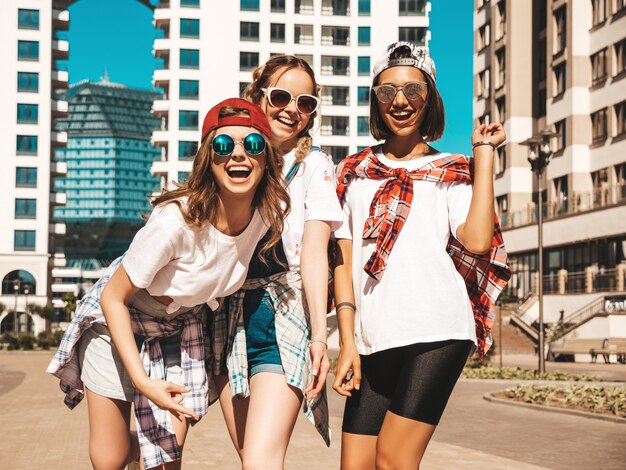 Retrato de três jovens bonitas garotas hipster sorridente em roupas da moda verão