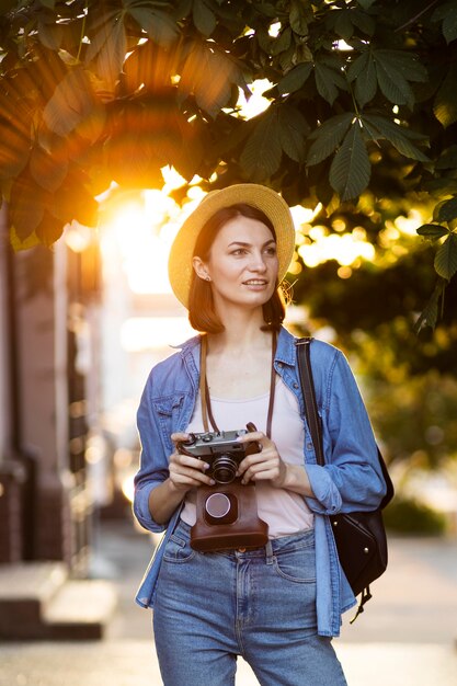 Retrato de turista com chapéu segurando a câmera