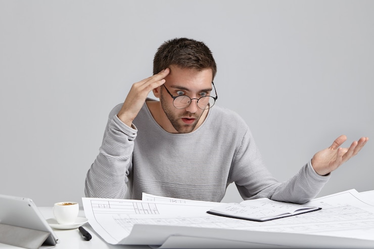Foto grátis retrato de um arquiteto ou designer masculino confuso, sentindo-se estressado, nervoso