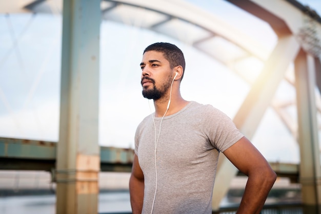 Retrato de um belo desportista com fones de ouvido se preparando para o treino