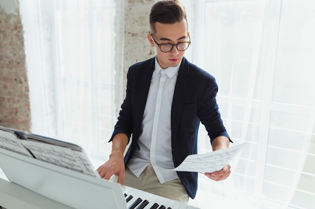 Retrato, de, um, bonito, homem jovem, olhar, musical, folha, piano jogo