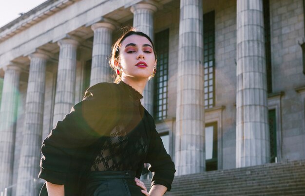 Retrato, de, um, bonito, mulher jovem, com, mãos quadril, frente, colonnade