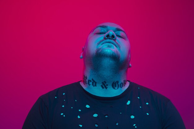 Retrato de um cara com luz de néon colorida no conceito cyberpunk de fundo vermelho