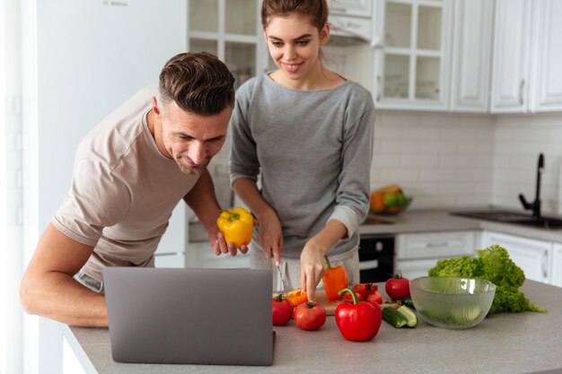 Retrato de um casal apaixonado sorridente cozinhar salada juntos