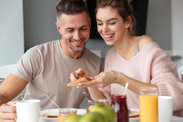 Retrato de um casal apaixonado sorridente tomando café da manhã