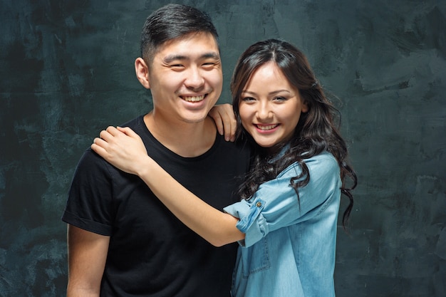 Retrato de um casal coreano sorridente em um cinza