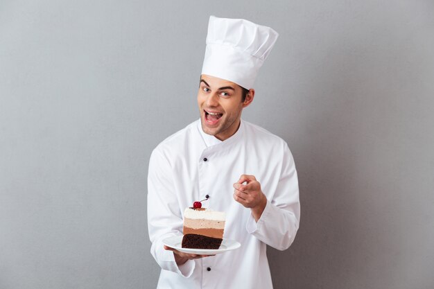 Retrato de um chef masculino alegre, vestido de uniforme