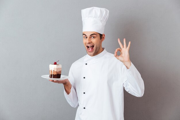 Retrato de um chef masculino feliz alegre vestido de uniforme