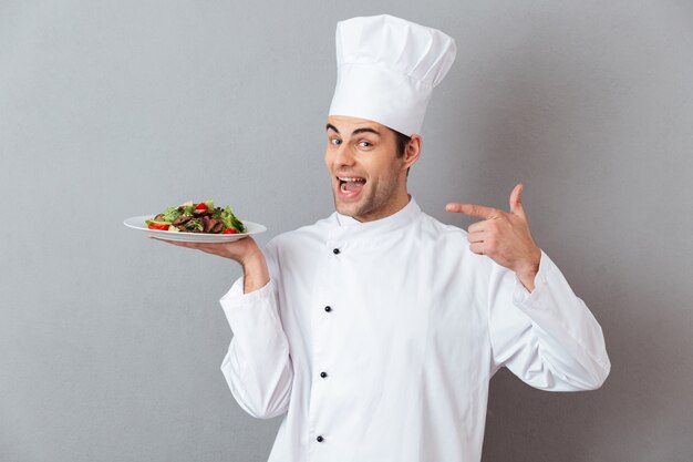 Retrato de um chef masculino feliz, vestido de uniforme