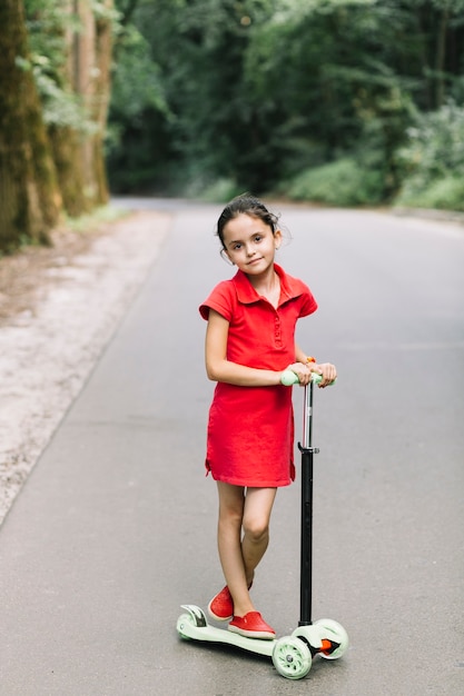 Retrato, de, um, cute, menina, ficar, sobre, scooters, ligado, estrada