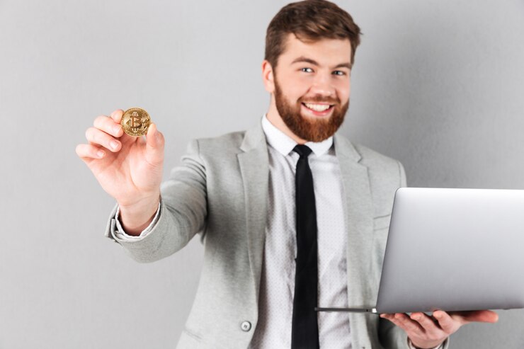 Foto grátis retrato de um empresário feliz mostrando bitcoin