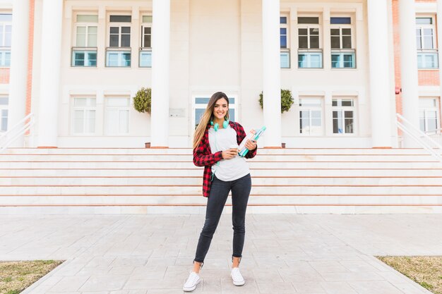 Retrato, de, um, estudante feminino, segurando, livros, em, mão, ficar, frente, faculdade