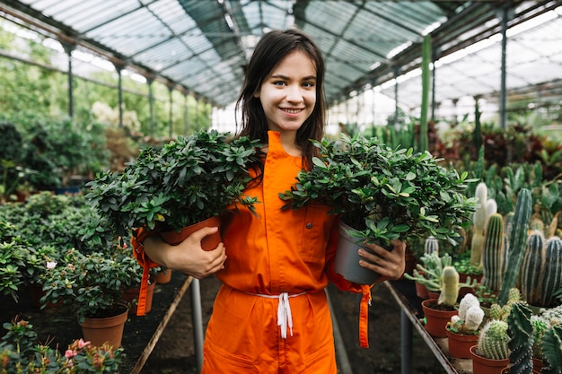 Retrato, de, um, feliz, femininas, jardineiro, segurando, dois, potted, plantas