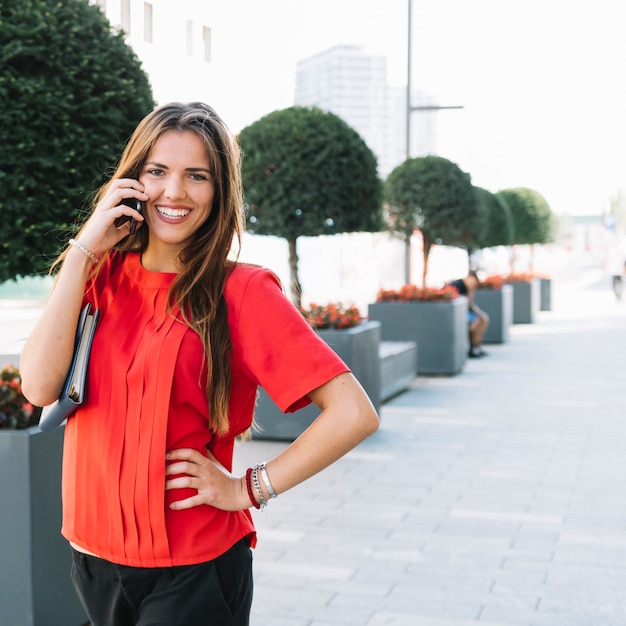 Retrato, de, um, feliz, mulher fala telefone móvel, em, cidade