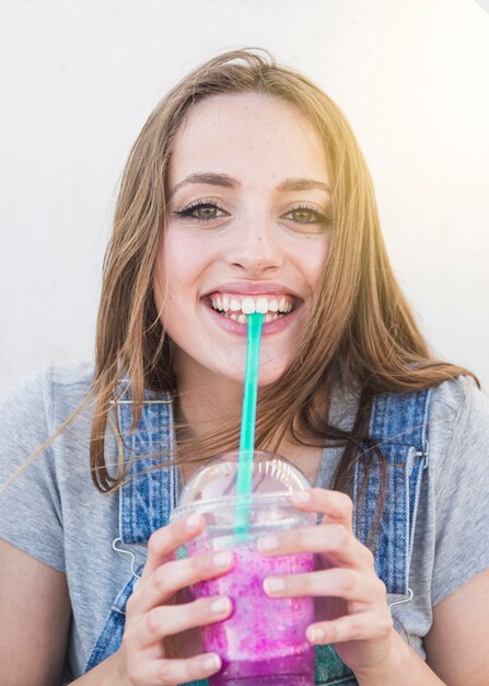 Retrato, de, um, feliz, mulher jovem, bebendo, suco