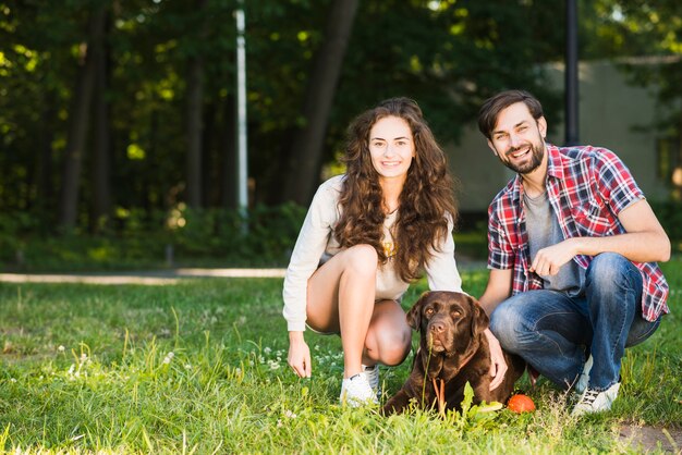 Retrato, de, um, feliz, par jovem, com, seu, cão, parque