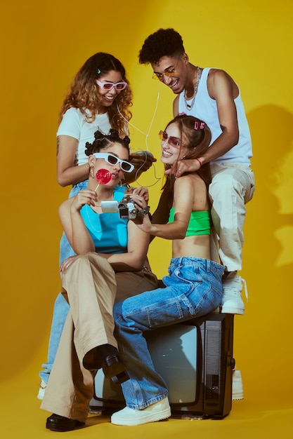 Retrato de um grupo de jovens amigos no estilo de moda dos anos 2000 posando com a câmera