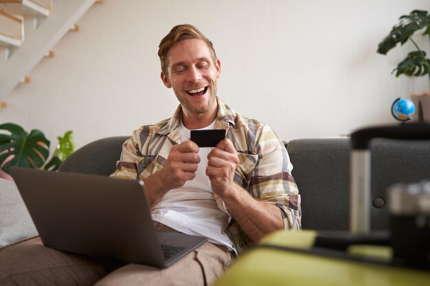 Foto grátis retrato de um homem a ir de férias a olhar para o seu cartão de crédito a comprar bilhetes online a reservar um hotel em