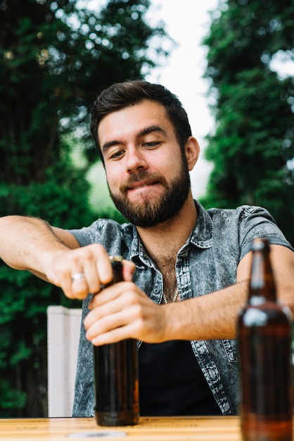 Retrato, de, um, homem, abertura, a, garrafa cerveja, boné