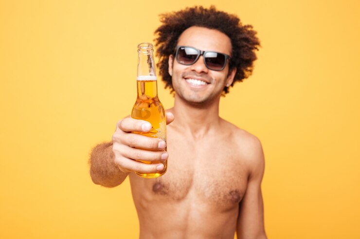 Foto grátis retrato de um homem africano em óculos de sol, mostrando a garrafa de cerveja