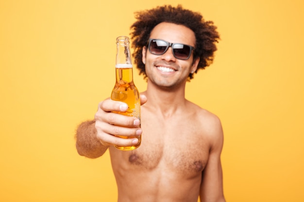 Retrato de um homem Africano em óculos de sol, mostrando a garrafa de cerveja