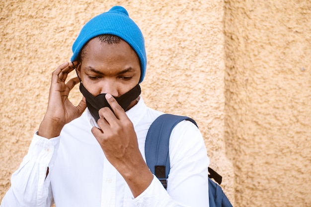 Foto grátis retrato de um homem afro-americano tentando remover sua máscara