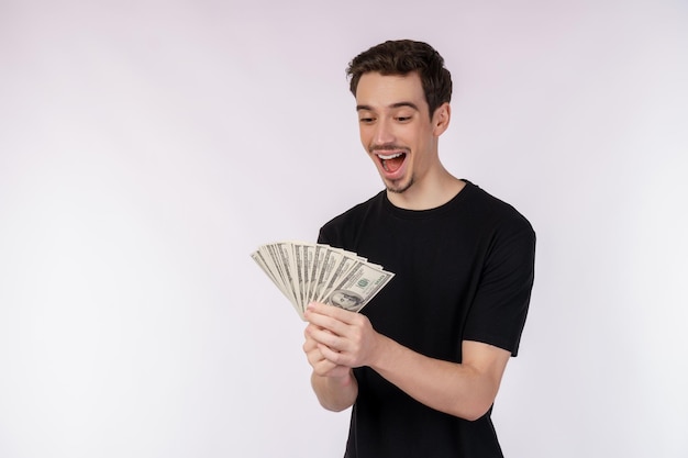 Retrato de um homem alegre segurando notas de dólar sobre fundo branco