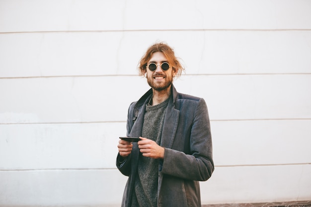 Retrato de um homem barbudo feliz usando óculos escuros