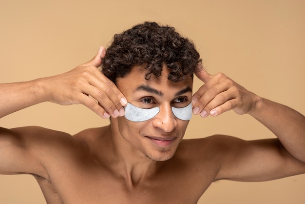 Retrato de um homem bonito aplicando tapa-olhos