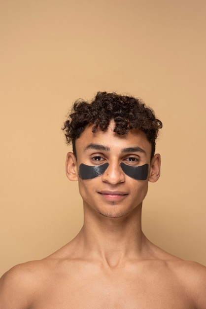 Retrato de um homem bonito usando manchas de carvão sob os olhos