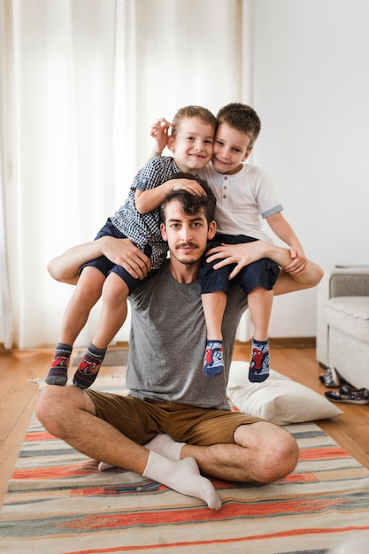 Retrato, de, um, homem, carregar, seu, dois filhos, ligado, ombro, casa