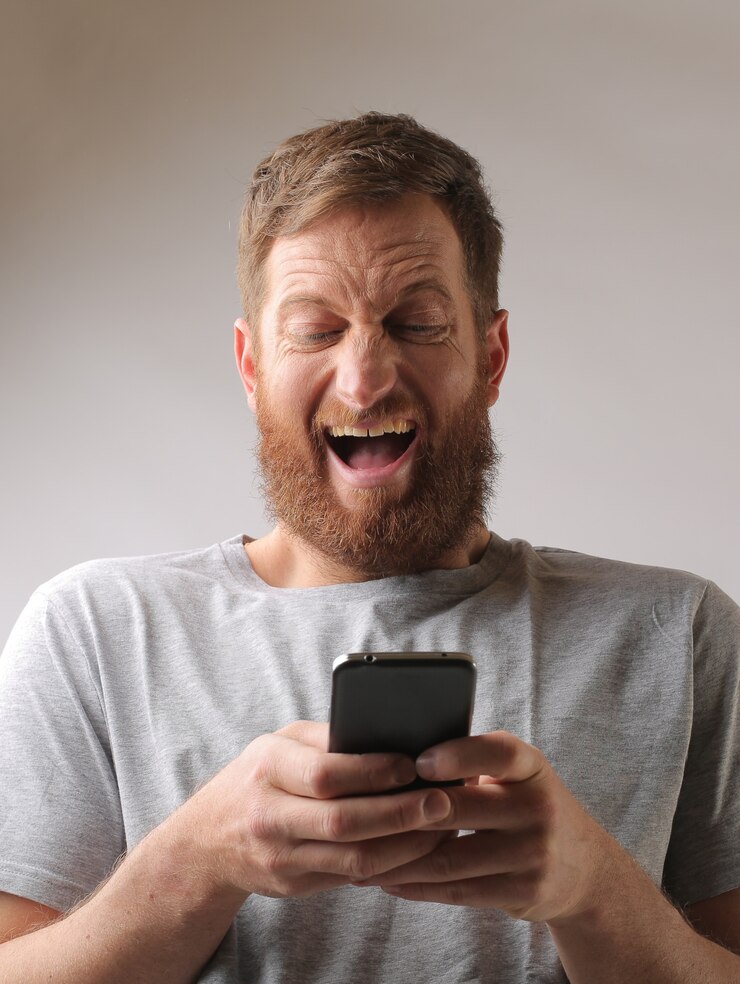 Foto grátis retrato de um homem com barba entusiasmado com uma mensagem de texto