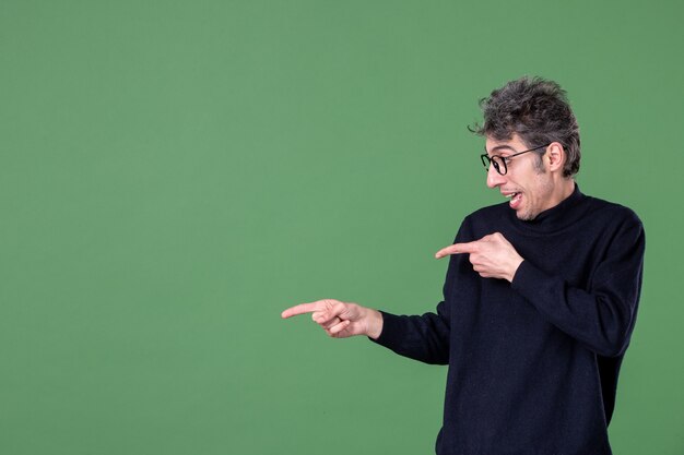 Retrato de um homem gênio vestido casualmente em estúdio, tiro na superfície verde cores horizontais da escola masculina