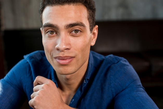 Retrato, de, um, homem jovem, em, camisa azul, olhando câmera