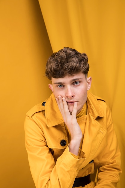 Foto grátis retrato, de, um, homem jovem, em, um, amarela, cena