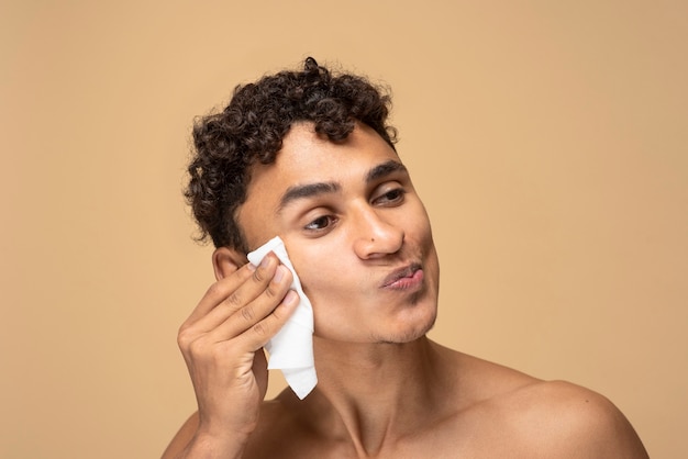 Foto grátis retrato de um homem limpando o rosto com um lenço de papel