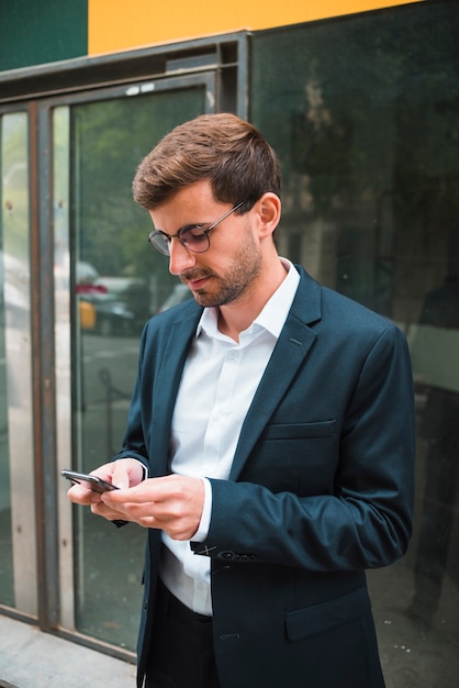Retrato, de, um, homem negócios, óculos usando, telefone móvel