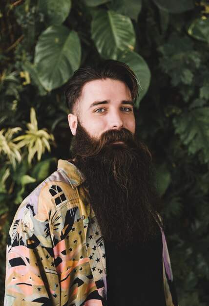 Retrato, de, um, homem, olhando câmera, frente, plantas