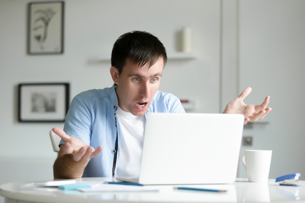 Retrato de um homem que trabalha na mesa com laptop