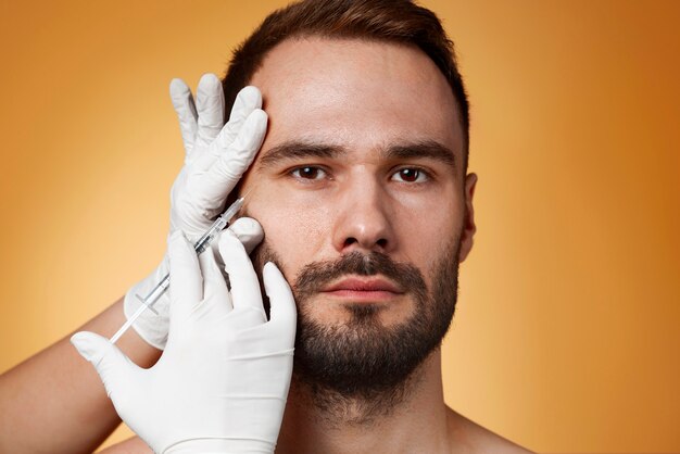 Retrato de um homem recebendo aprimoramentos e ajustes através da ajuda de procedimentos cosméticos.