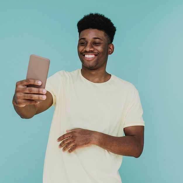 Retrato de um homem sorridente a tirar uma selfie